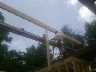 Carpenter setting a ridge beam over a new addition frame — Ice Dam Removal by Roofing Brothers in Turlock
