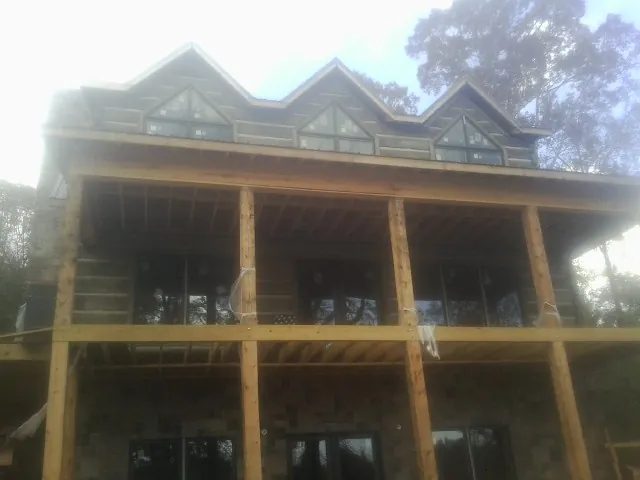 Dormers and porch framing on a large log home under construction — Roof Coating work by our crew in Turlock