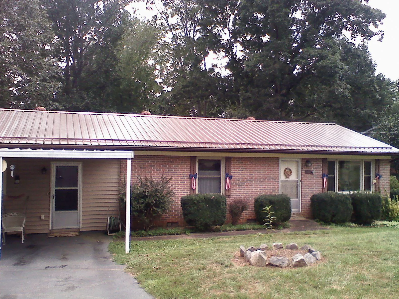 Bronze metal roof and carport on a brick ranch home — Roof Repair work by our crew in Turlock