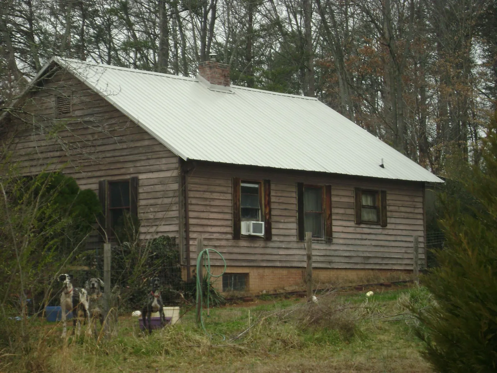 White metal roof on an old wood sided farmhouse, from a Metal Roof Installation job in Turlock